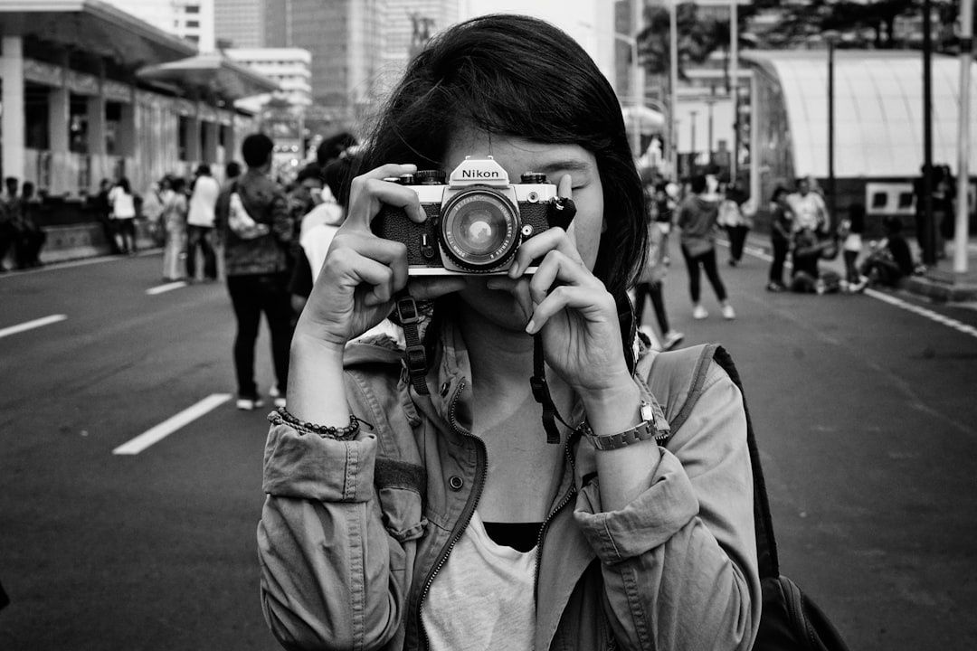 Fotografin mit Nikon-Kamera fotografiert im belebten Stadtverkehr